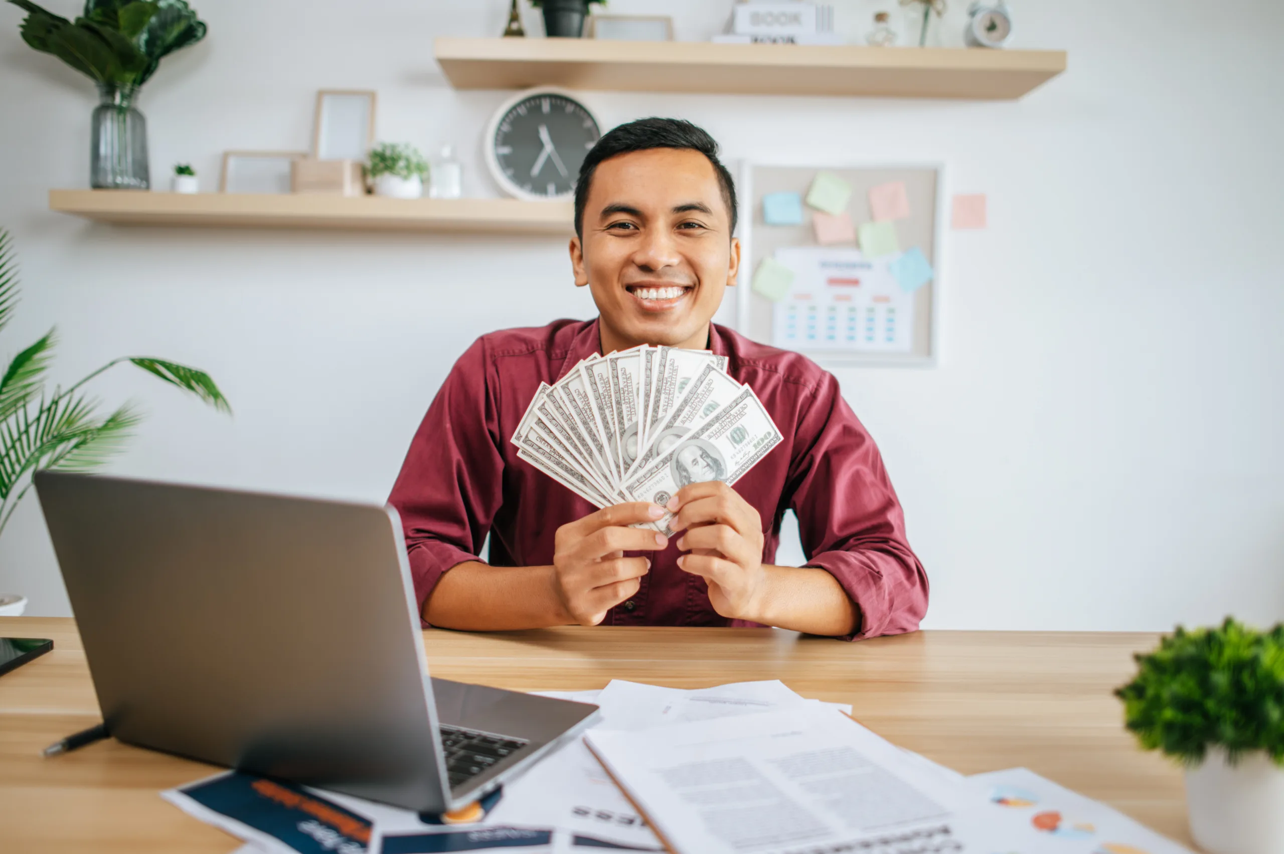 man working office holding money with laptop documents desk 2 scaled Lowongan Penulis Pustaka Albahjah, Lomba Artikel Gratis Dibayar Rp50rb Perbulan!